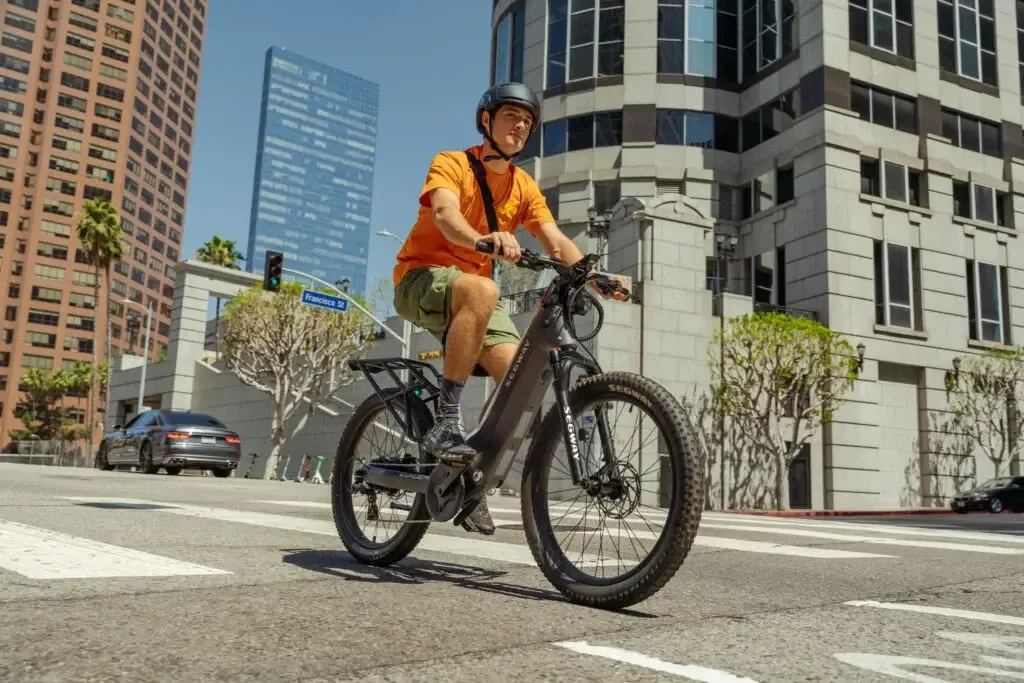 Rider commuting through the city on an e-bike with a backpack